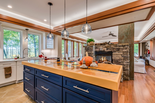 Custom kitchen island with navy blue shaker panels and butcherblock countertop for warm practical prep space
