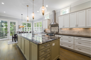 Custom kitchen island with olive green shaker drawers and panels paired with white cabinetry for contrast