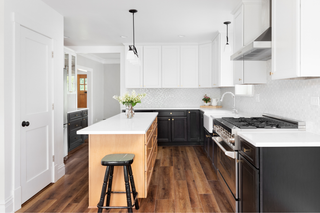 Custom kitchen island with three-tone cabinetry and shaker styling creating layered wood and paint contrast