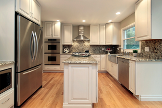 Custom kitchen island with white raised panel doors and marble countertops for a traditional statement island