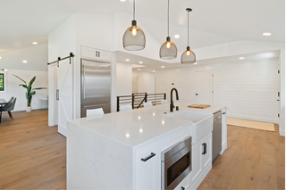 Custom kitchen island in clean minimalist white shaker style with simple lines and streamlined storage