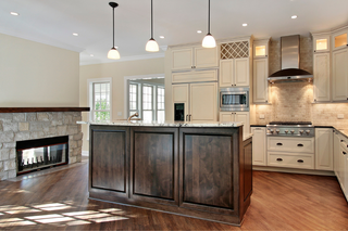 Custom kitchen island in walnut wood paired with white cabinets for a warm contrast focal point