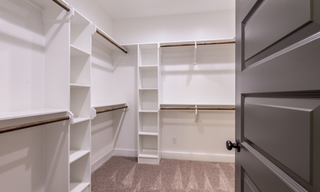 Custom reach-in closet with built-in shelving, drawers, and hanging storage