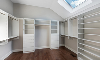 Large custom walk-in closet with built-in shelving, drawers, cabinetry, and hanging storage