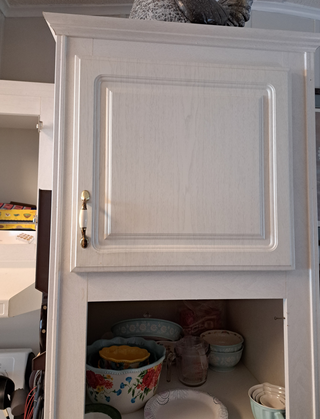 Before kitchen showing older cabinet doors and dated hardware