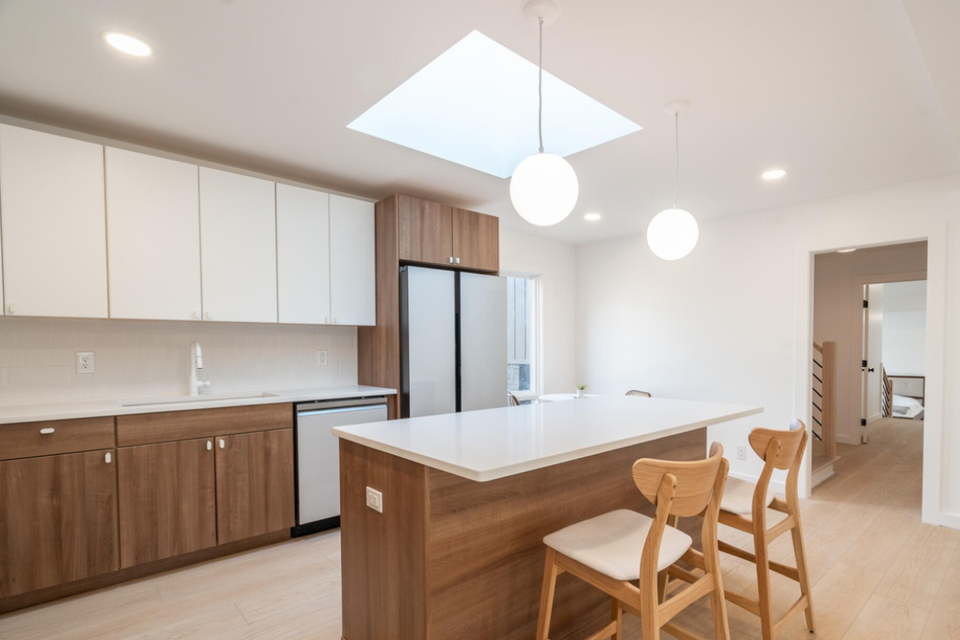Custom kitchen cabinets with Modern Turino thermofoil doors and white countertops in a mid-century modern kitchen