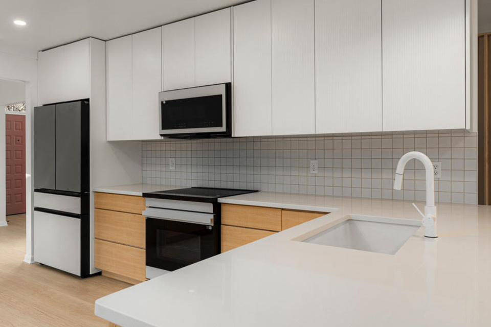 Modern slab custom kitchen cabinets with light wood thermofoil and clean Scandinavian styling