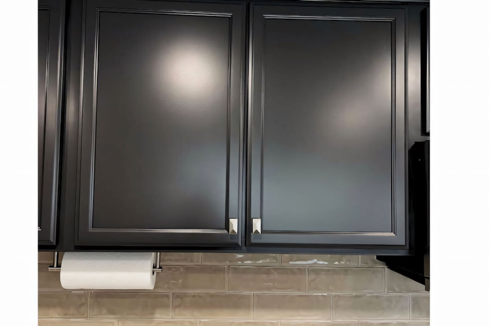 Custom built-in real life project showing black kitchen cabinets refacing with detailed trim and hardware