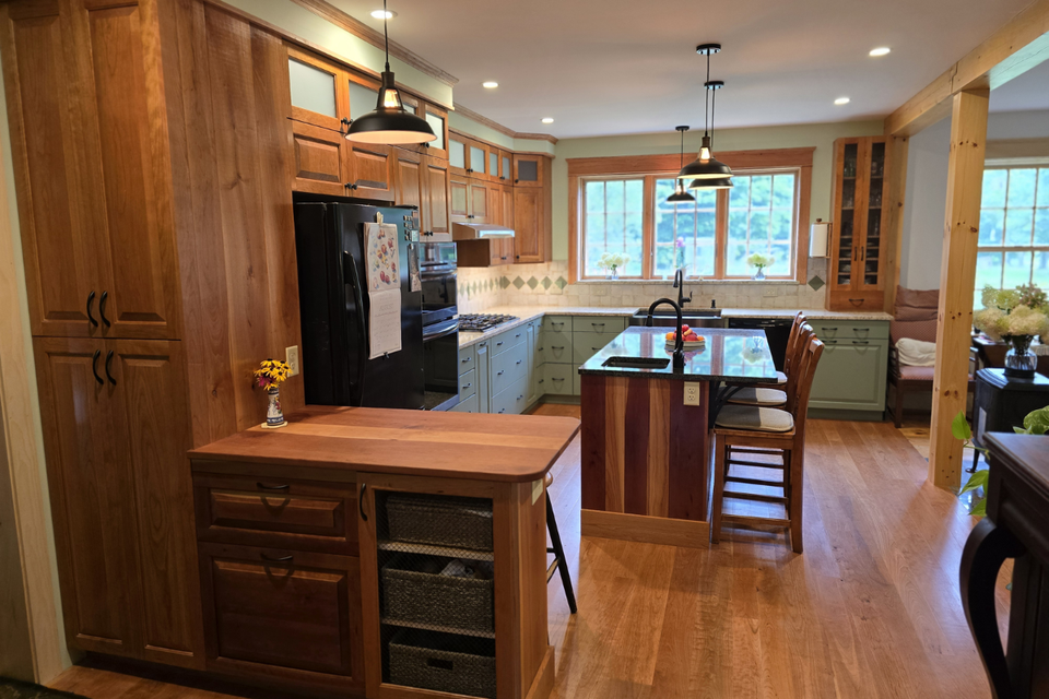 Custom kitchen cabinets with cherry wood doors and green painted cabinetry in a two-tone kitchen by Will
