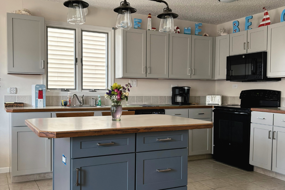 Custom kitchen cabinets real life project in a beach home with mindful gray shaker doors and midnight grey island