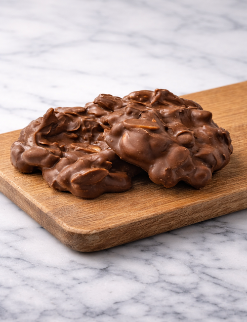 milk chocolate peanut cluster on wood tray 