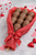 milk chocolate strawberry skewers wrapped in red tissue paper
