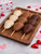 trio chocolate strawberry skewers on wood tray