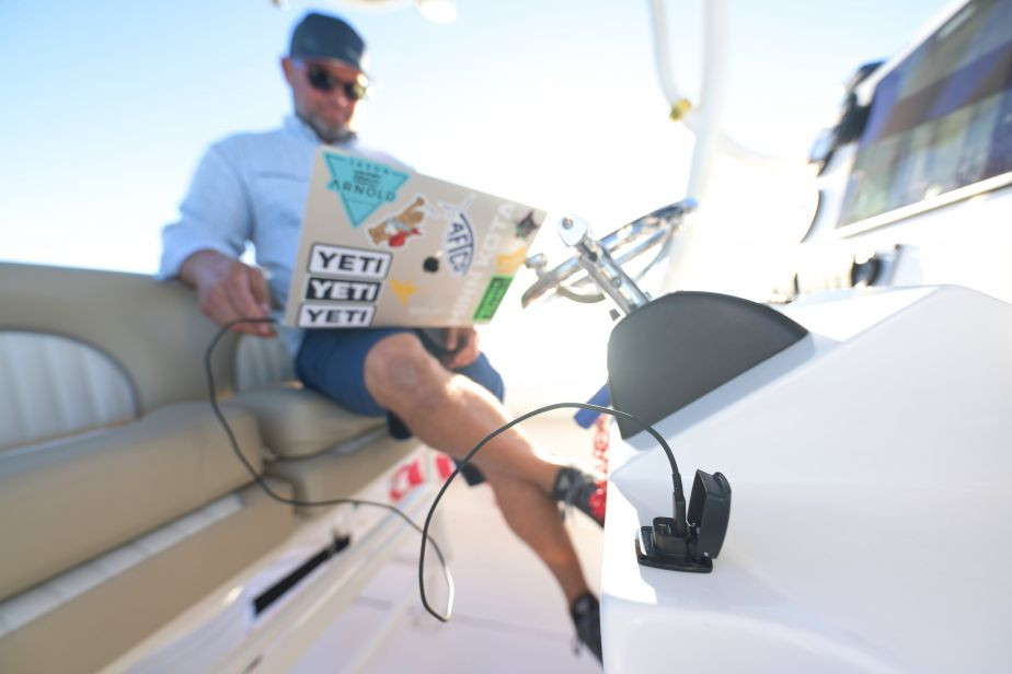 Scanstrut ROKK Flip Pro Rapid Dual USB-A/C Charger being used to charge a man's laptop