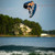 Hyperlite Motive Jr. Wakeboard w/ Remix Kids Boots 2023 - Pro rider flying through the air pulling a grab trick