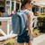 Woman walking with a steel blue Mission CASSI 18L backpack