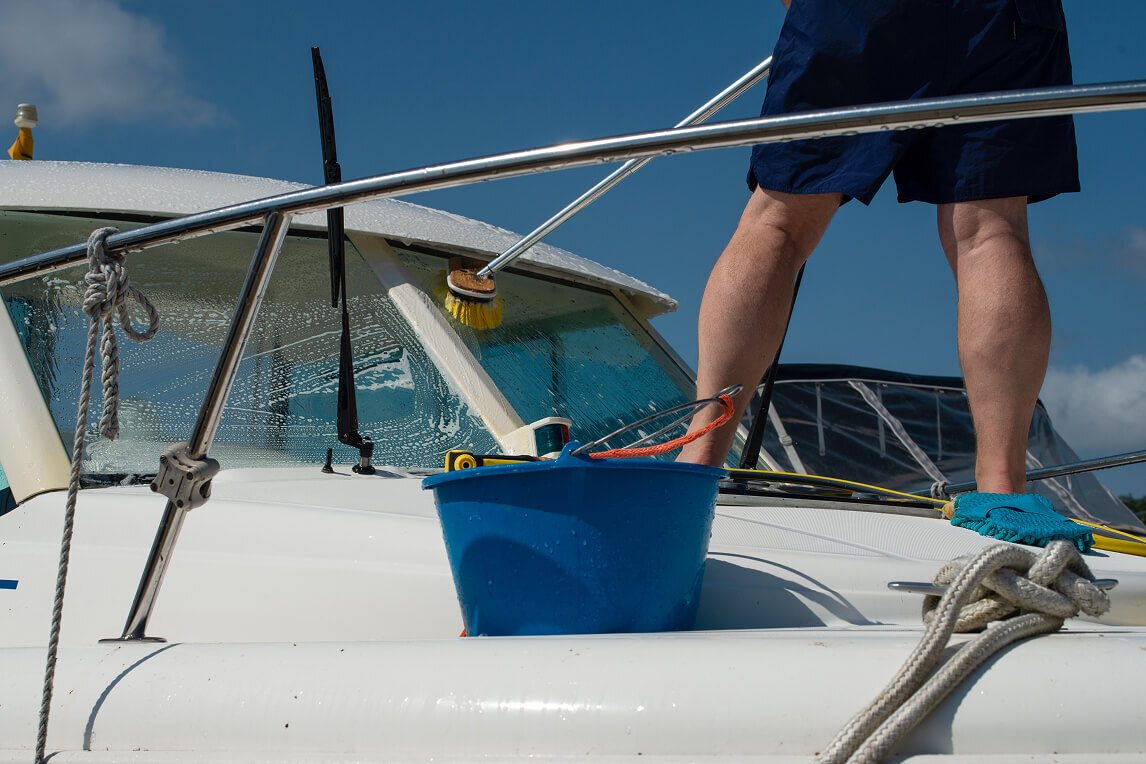 Man cleaning a boat with a scrub brush