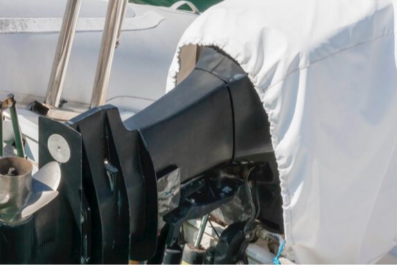 White fitted boat motor cover shielding outboard cowling from sun and salt