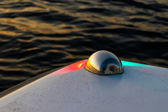 Red and green navigation lights on a boat at dusk.