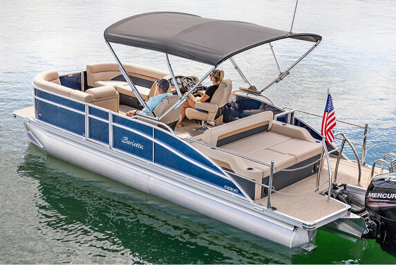 A stylish blue and tan pontoon boat with a black canopy floats on calm water.