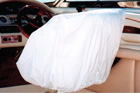 Elastic white helm seat cover safeguarding cockpit upholstery on runabout