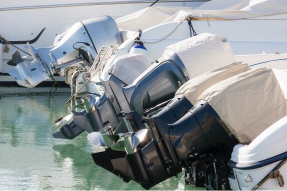 Multiple moored boats with tan outboard motor covers
