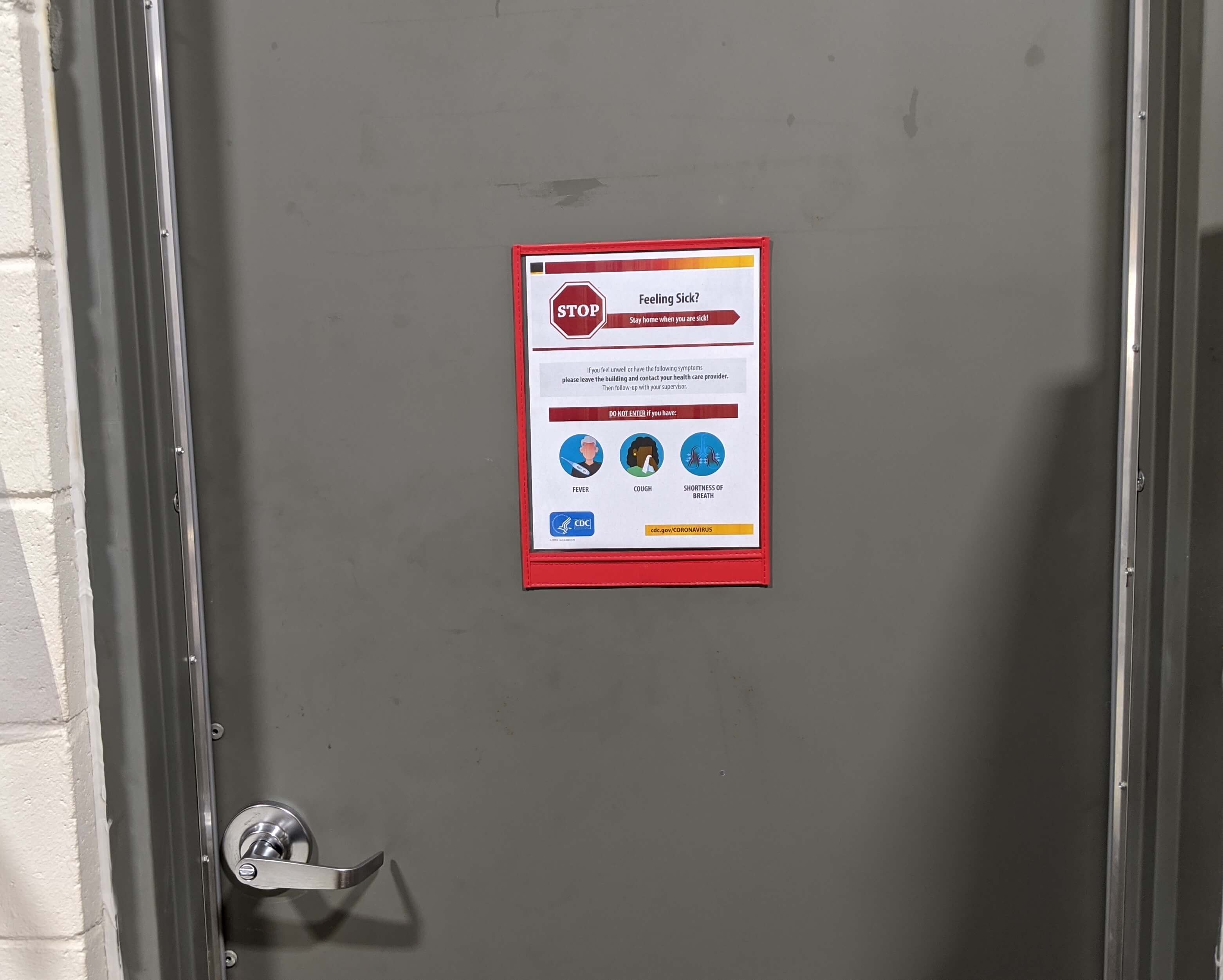 Magnetic safety 9x12 plastic sign holder with red sticthed vinyl trim mounted on a steel entrance door with safety poster. shown orientated upside down to keep opening onbottom to prevent dust and light splashes from entering and damaging the poster