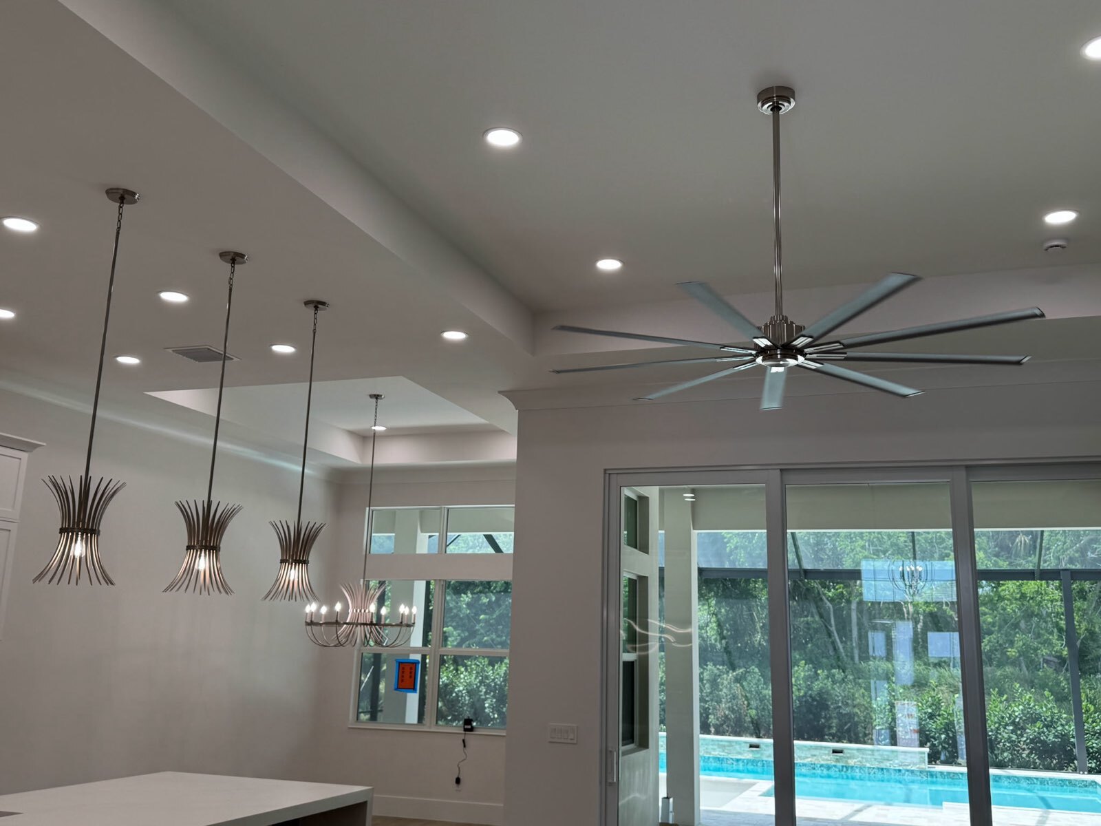 hanging lights in a modern kitchen with windows and a modern ceiling fan