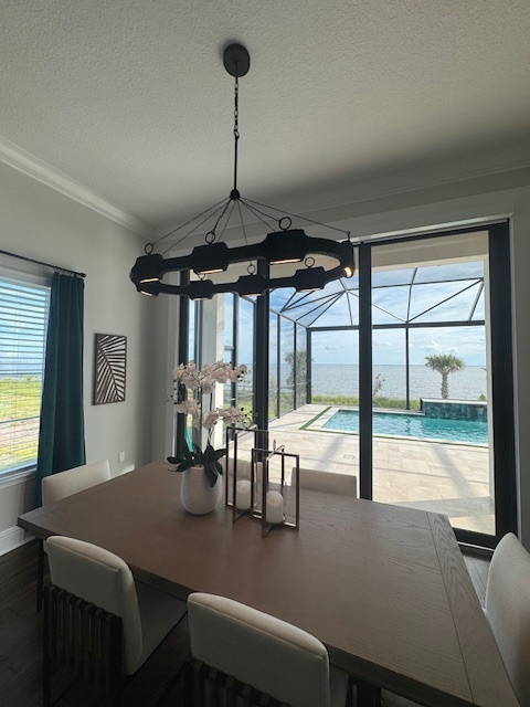 dining room with a modern chandelier with a large window showing the back pool
