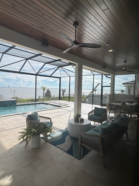 a covered patio with modern ceiling fans tile flooring and a pool