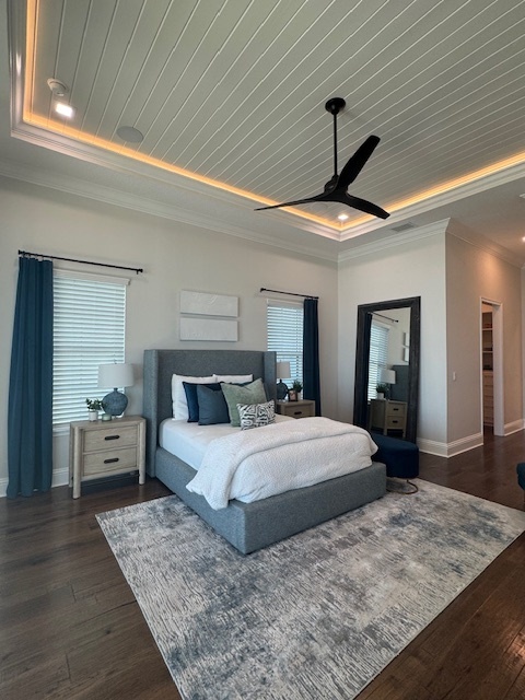 bedroom with wood floors crown molding and a modern ceiling fan