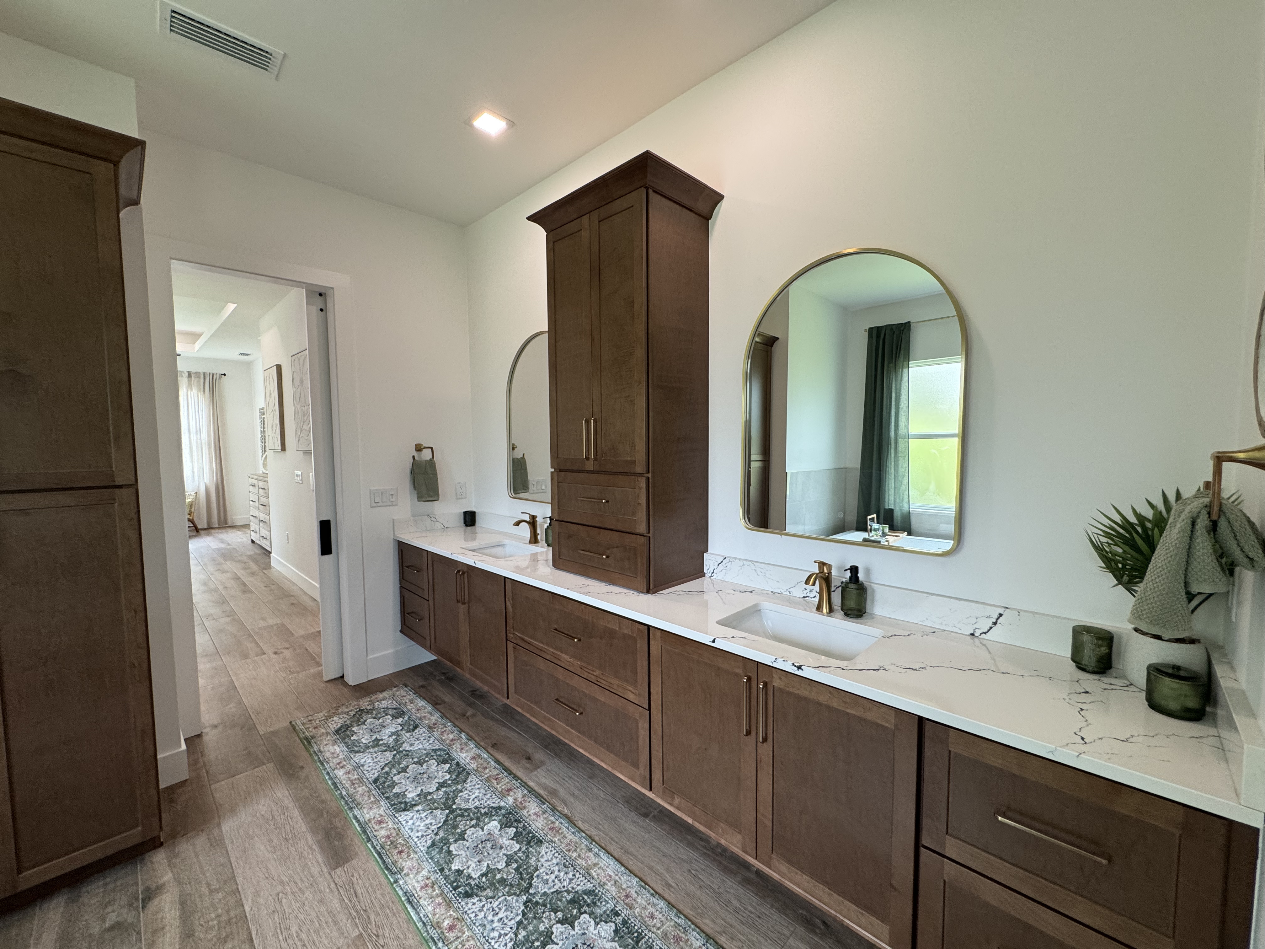 a bathroom with marble countertops and dark wood cabinets
