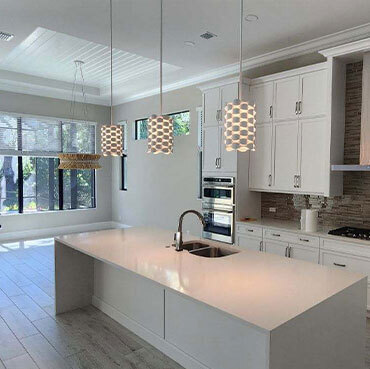 3 hanging pendant lights above a kitchen island