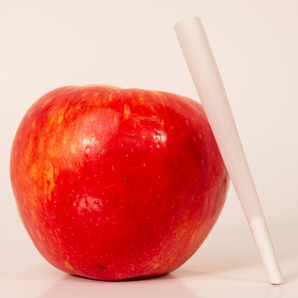 pre-rolled cone leaning against an apple