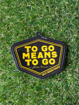 a single tag sticker laying on a grass background showing the hole where you can fix this sticker to your product. Tag sticker is coated in matte silk lamination.