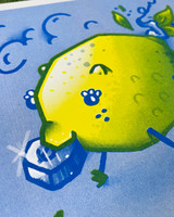 Image up close angle of details of an Art print is in two colors Yellow + Blue mixing to make greens. Art Depicts a lemon fashioned as a pig as you would create a "New Year's Lemon Pig"
