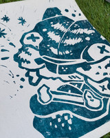 Image featuring a one color art print using teal ink with a grass background. Image is an up close angle of a illustrated tiger head