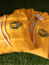 image of the two hoodie options, one with zipper, one without, on a green grass background. hoodie is gold yellow with green prints. both are folded with white draw strings
