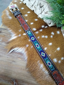 This western belt from Twisted X features tooled leather and a beaded blue Aztec design. It's 1 1/4'' wide with a removable silver buckle. This western belt from Twisted X features tooled leather and a beaded blue Aztec design. It's 1 1/4'' wide with a removable silver buckle.