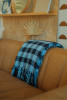 Throw Blanket from Reclaimed Fibers of 100% Post-Consumer Materials modeled over a couch