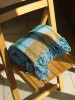 Throw Blanket from Reclaimed Fibers of 100% Post-Consumer Materials modeled on a chair