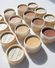An array of shades of Vegan Zero Waste Concealer in paper pots