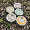 Five colorful natural heal-all balms in aluminum twist tins