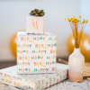 Multiple gifts wrapped in compostable and reversible happy birthday and candles wrapping paper