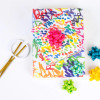 Multiple gifts wrapped in compostable and reversible funfetti and squiggles wrapping paper