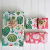 Multiple gifts wrapped in compostable and reversible pink white and green watercolor cactus wrapping paper