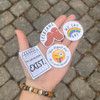 A palm holding colorful pride LGBTQIA support stickers