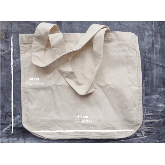 A Multi-Pocket Organic Cotton Tote Bag laying empty and flat on a chalkboard background with dimensions