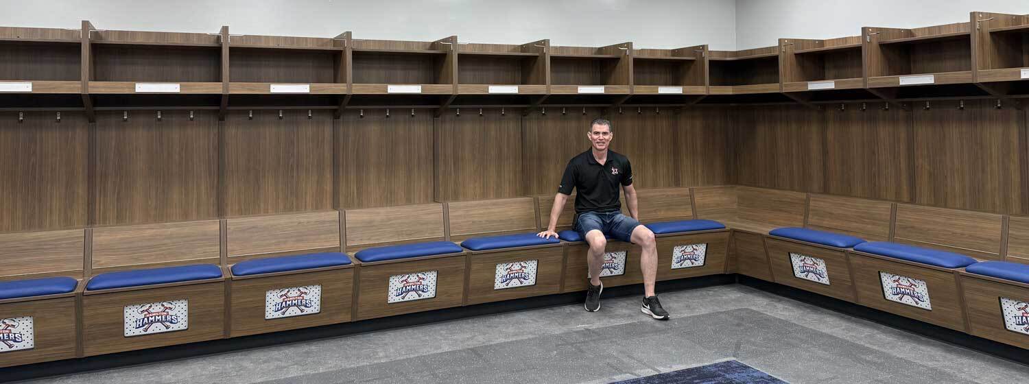 Complete team dressing room locker install by xHockeyProducts with logo panels and seat cushions