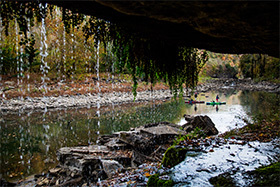 paddlers as viewed through a waterfall